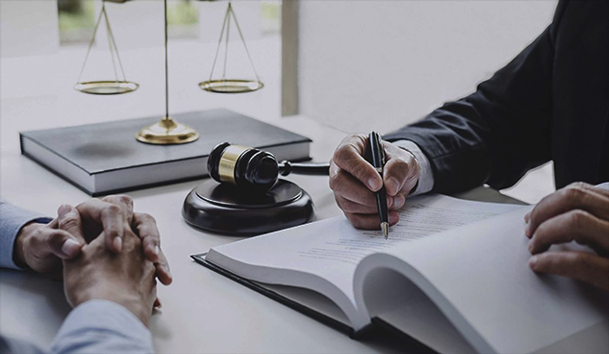 Client signing documents at an attorney’s desk